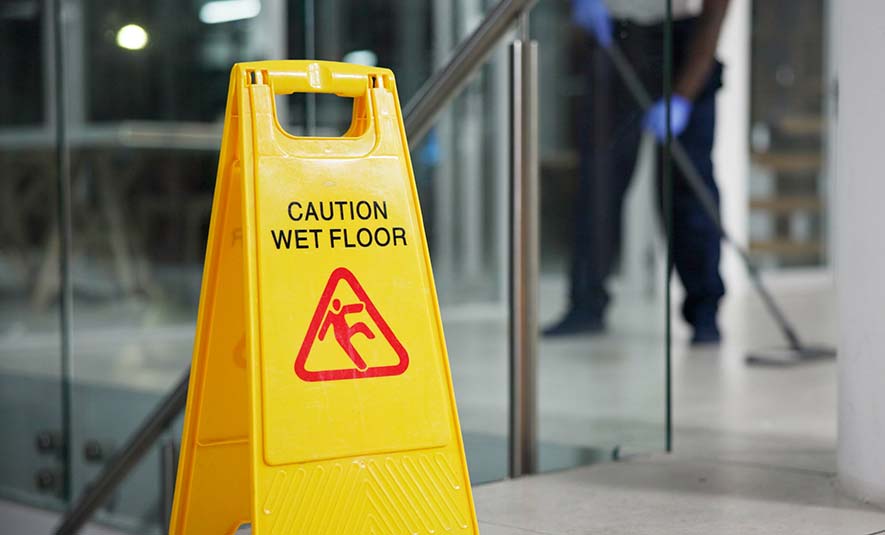 cleaning sign in foreground with a cleaner cleaning
